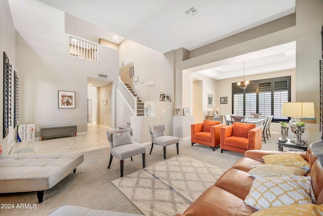 living room with light colored carpet, a raised ceiling, and a notable chandelier