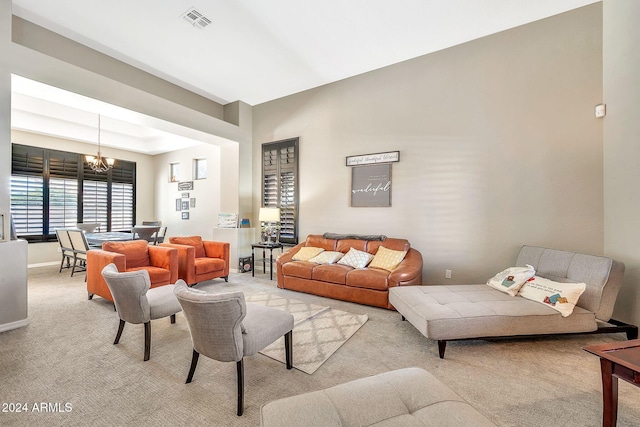 carpeted living room featuring an inviting chandelier