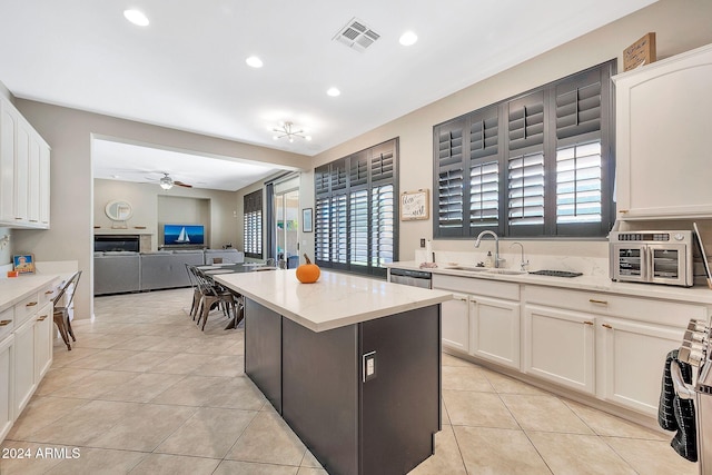 kitchen with white cabinetry, a center island, and light tile patterned floors