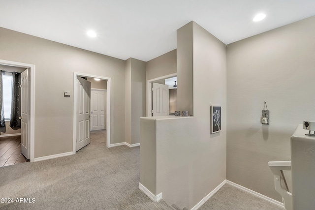 hallway featuring light colored carpet