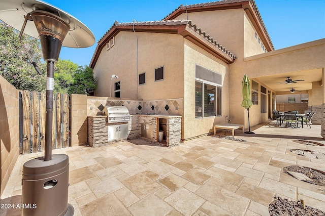 view of patio featuring an outdoor kitchen, area for grilling, and ceiling fan