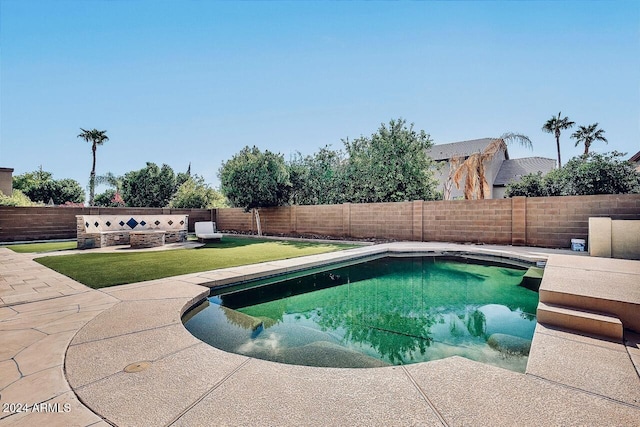 view of swimming pool featuring a lawn and a patio