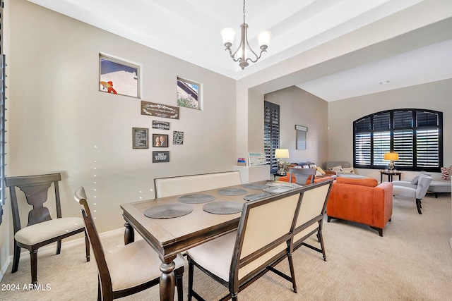 dining area with light carpet and a chandelier