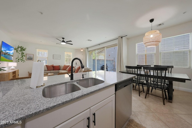 kitchen featuring decorative light fixtures, light tile patterned floors, visible vents, stainless steel dishwasher, and a sink