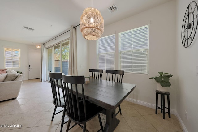 dining room featuring a healthy amount of sunlight, light tile patterned floors, and visible vents