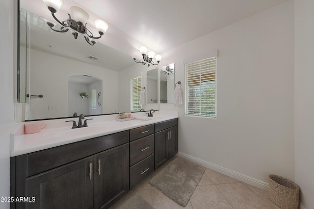 full bath with visible vents, a sink, baseboards, and double vanity