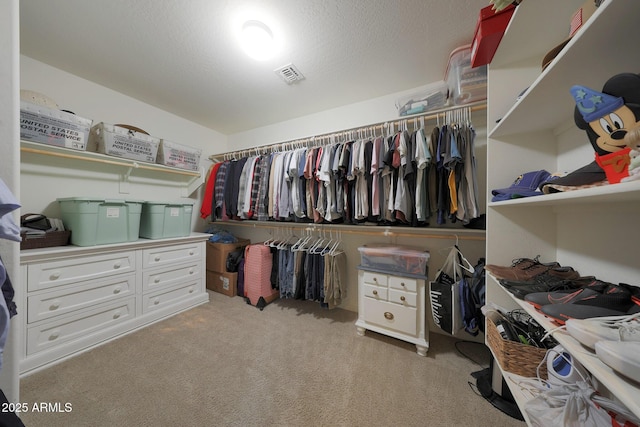 walk in closet featuring light carpet and visible vents