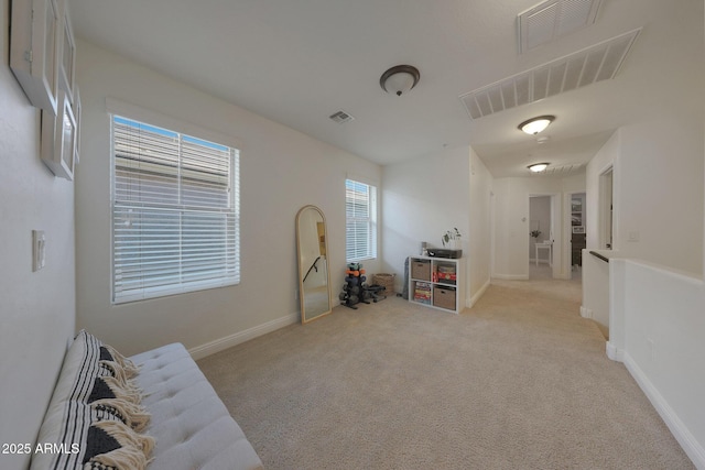 interior space featuring light carpet, baseboards, and visible vents