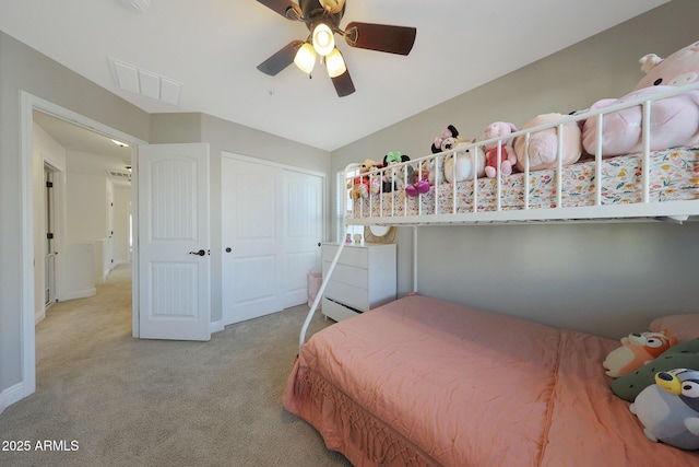 carpeted bedroom featuring a baseboard heating unit, ceiling fan, a closet, and visible vents