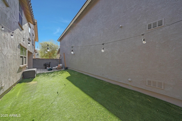 view of yard featuring fence and visible vents