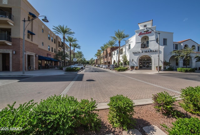 view of street featuring street lights, sidewalks, curbs, a residential view, and traffic signs