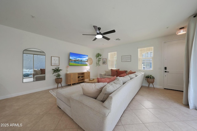 living area with light tile patterned floors, a ceiling fan, visible vents, and baseboards