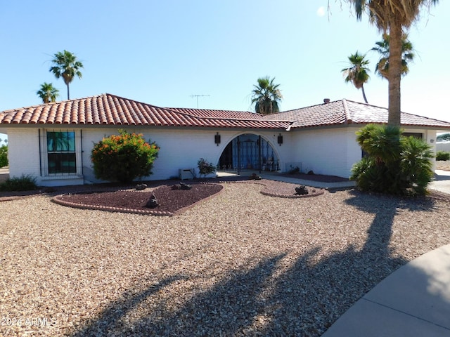 view of front of house with a tiled roof and brick siding