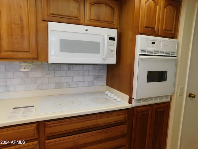 kitchen featuring tasteful backsplash and white appliances