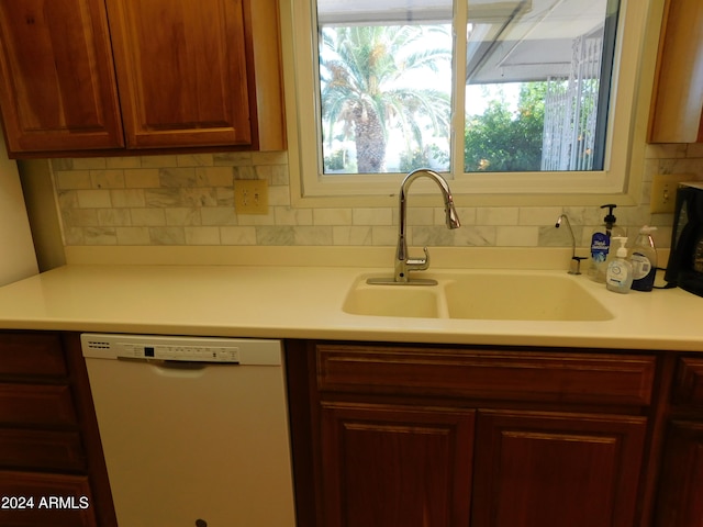 kitchen featuring decorative backsplash, sink, and white dishwasher