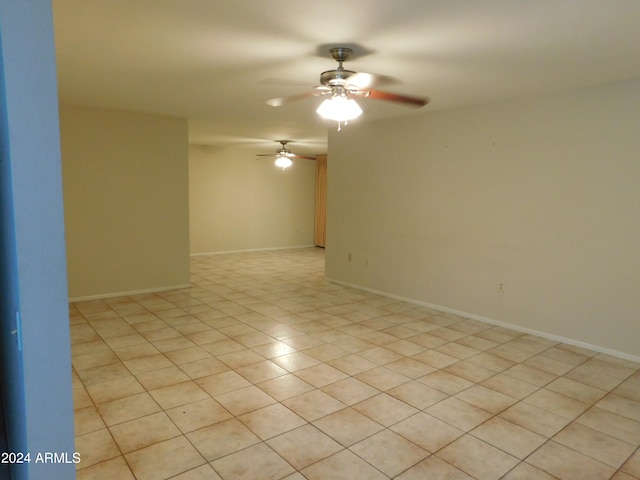 tiled spare room featuring ceiling fan