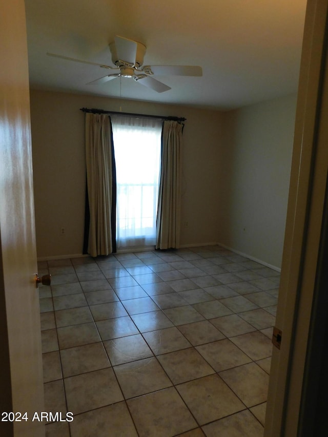 empty room featuring light tile patterned floors and ceiling fan