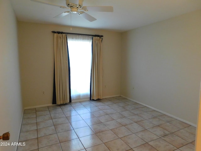 spare room featuring light tile patterned flooring, baseboards, and ceiling fan