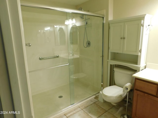 full bath featuring tile patterned floors, vanity, toilet, and a shower stall