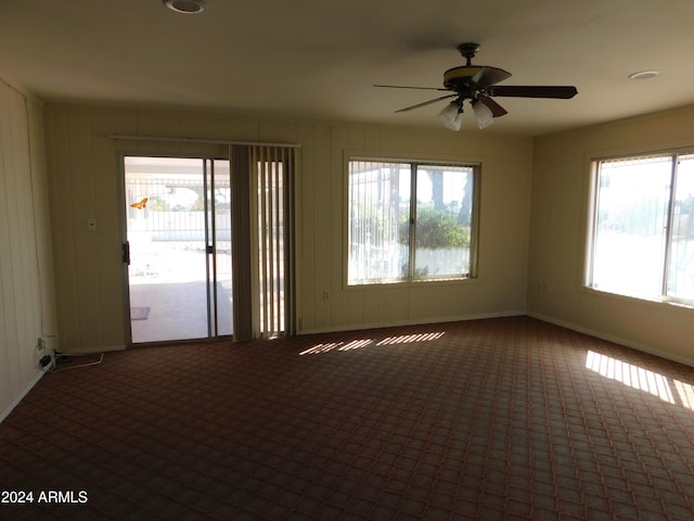 empty room featuring carpet flooring, a wealth of natural light, and ceiling fan