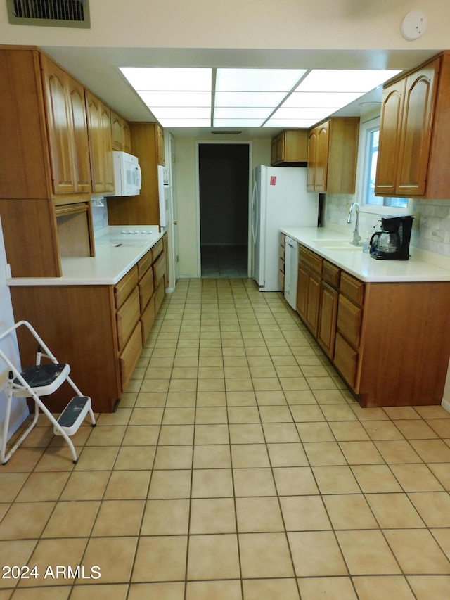 kitchen featuring tasteful backsplash, white appliances, sink, and light tile patterned floors