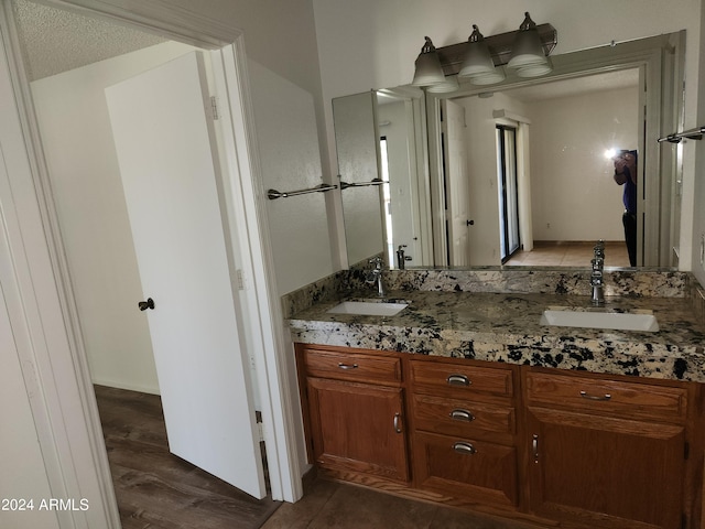 bathroom with dual vanity, tile flooring, and a textured ceiling