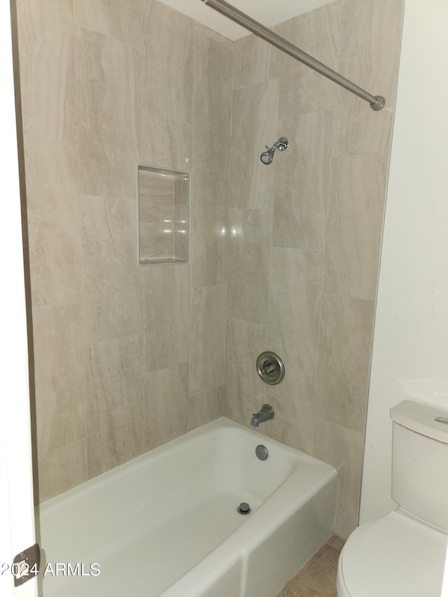 bathroom featuring tiled shower / bath combo and toilet