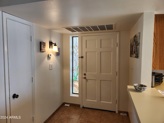 tiled entrance foyer featuring a textured ceiling