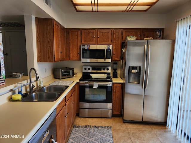 kitchen featuring sink, light tile flooring, and appliances with stainless steel finishes