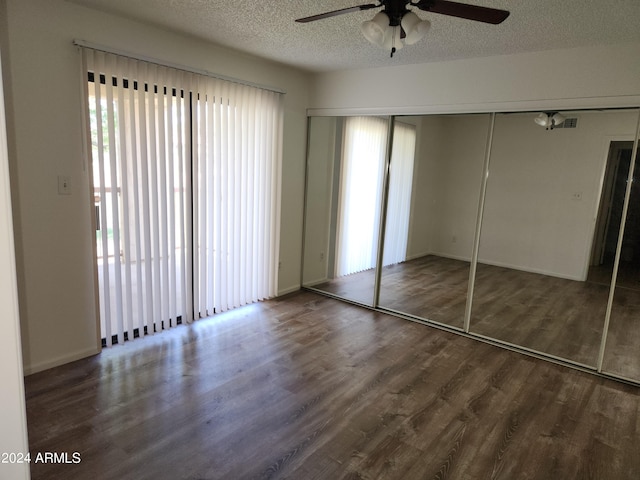 unfurnished bedroom with a textured ceiling, a closet, ceiling fan, and dark hardwood / wood-style flooring