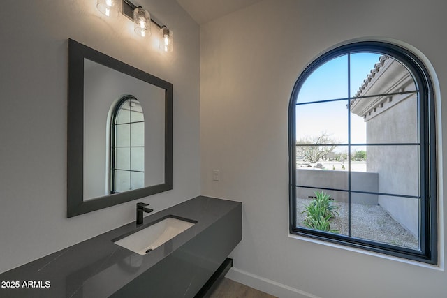 bathroom featuring baseboards and a sink