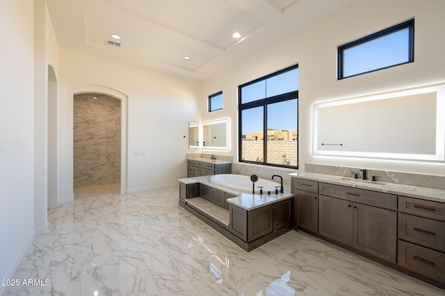 full bathroom featuring a garden tub, visible vents, marble finish floor, and a sink