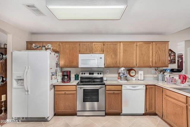 kitchen featuring light tile patterned floors, visible vents, white appliances, and light countertops