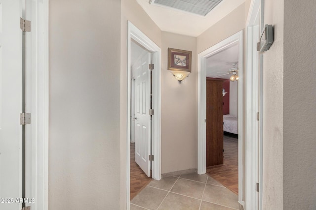 corridor featuring light tile patterned flooring and visible vents