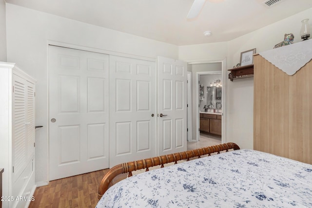 bedroom featuring a closet, light wood-style floors, visible vents, and ceiling fan