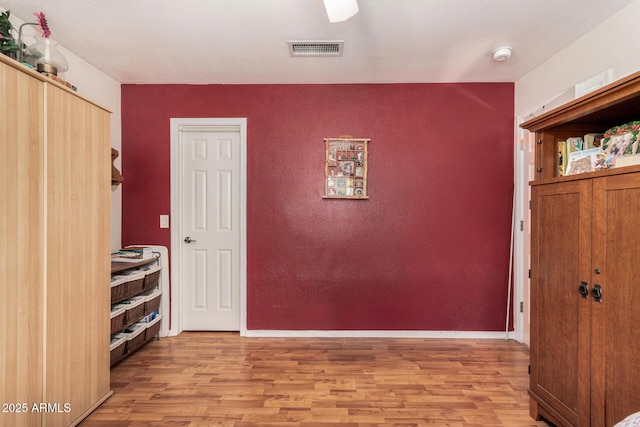 interior space featuring baseboards, visible vents, and light wood-type flooring