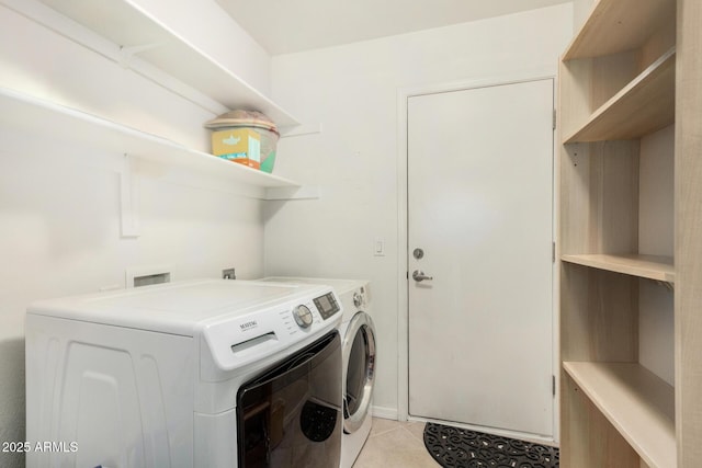 laundry room with light tile patterned flooring, washing machine and dryer, and laundry area