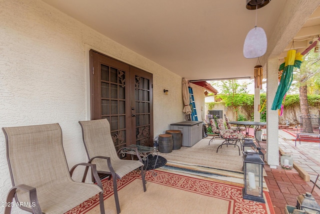 view of patio with outdoor dining area, fence, and french doors