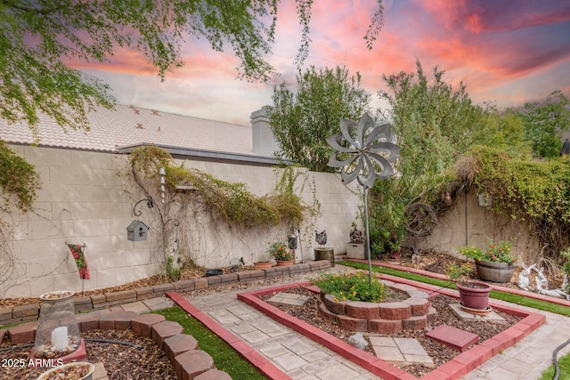 patio terrace at dusk featuring fence