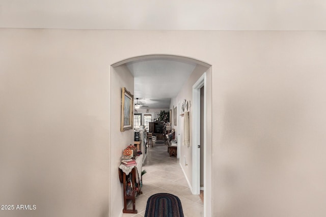 hallway with light tile patterned floors and arched walkways