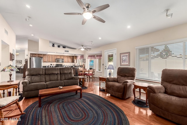 living room featuring visible vents, lofted ceiling, ceiling fan, light wood-type flooring, and recessed lighting