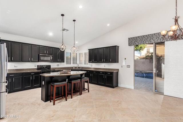 kitchen with a breakfast bar area, stainless steel appliances, visible vents, a center island, and decorative light fixtures