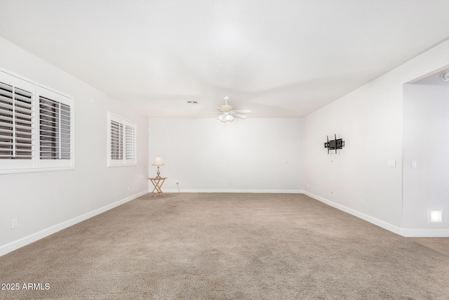 unfurnished room featuring a ceiling fan, carpet, and baseboards