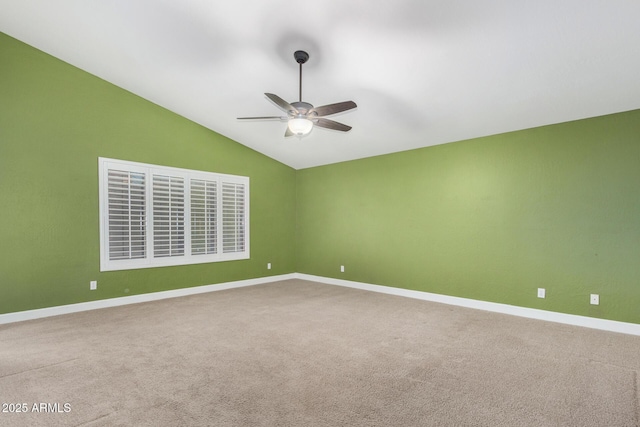 carpeted spare room featuring a ceiling fan, lofted ceiling, and baseboards