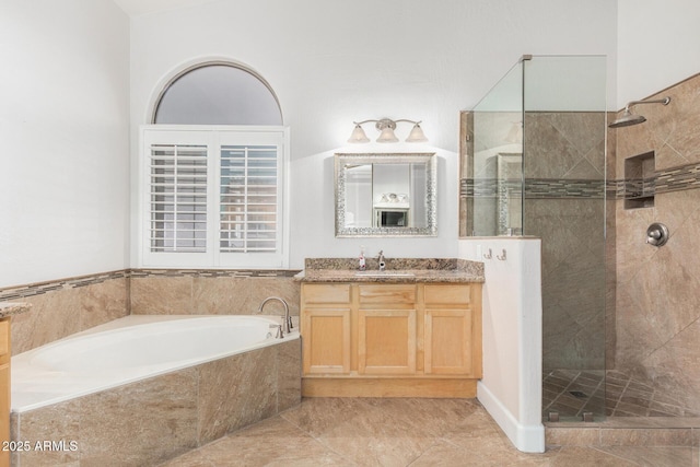 bathroom featuring a tile shower, a bath, and vanity