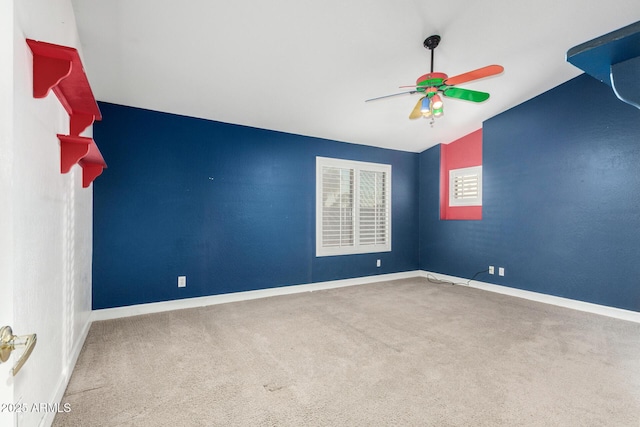 unfurnished room featuring vaulted ceiling, carpet floors, a ceiling fan, and baseboards