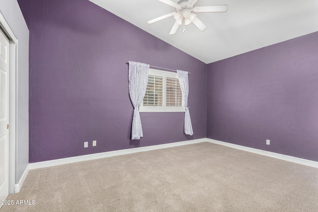 unfurnished room featuring carpet floors, vaulted ceiling, baseboards, and ceiling fan