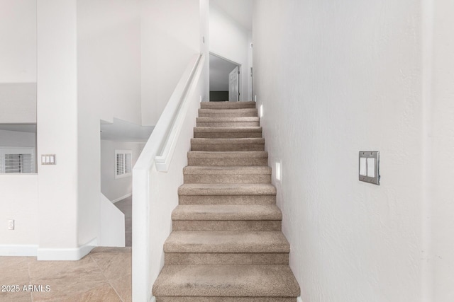 stairs with baseboards, visible vents, and tile patterned flooring