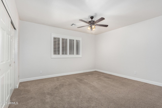 spare room featuring baseboards, carpet floors, visible vents, and a ceiling fan