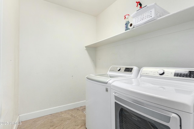 laundry room with light tile patterned floors, laundry area, washing machine and clothes dryer, and baseboards